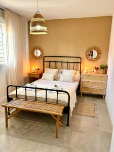a bedroom with a bed and a bench in it at GATU Villa Luna Casa de campo con piscina privada in Melegis