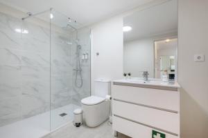 Un baño blanco con ducha y WC. en Beach Front Apartment Av dos Banhos, en Póvoa de Varzim 14 fotos más