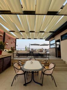 eine Terrasse mit Tisch und Stühlen unter einer Decke in der Unterkunft Adriatic Apartments in Ulcinj
