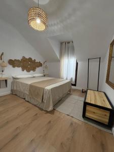a bedroom with a large bed and a table at Casa Mariquilla in Antequera +13 photos