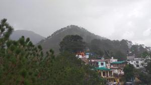 un grupo de casas en una colina con una montaña en Sun Homes, en Bhowāli