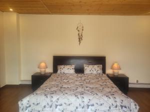 ein Schlafzimmer mit einem großen Bett und zwei Lampen in der Unterkunft Romana in Ar Rummān