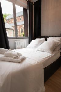 two beds in a room with a large window at Le Passion Room - Love Room - Jacuzzi in Beauvais
