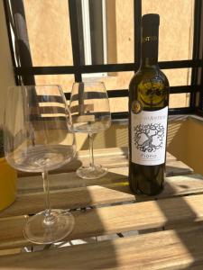 a bottle of wine and two glasses on a table at Nas's House in Ronciglione