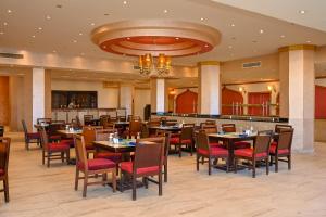 a restaurant with tables and chairs and a bar at Le Jardin Aqua Park Resort in Hurghada