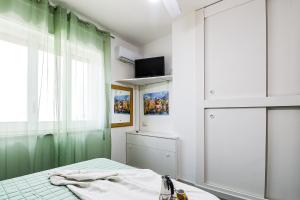 a bedroom with a bed and a window and a television at Tamarè 1 by Casa di Marco AP24 in Lido Conchiglie