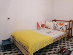 a bedroom with a bed with a yellow blanket at Ella Mountain Inn in Ella
