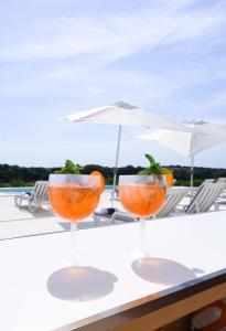 two cocktails sitting on a table with an umbrella at Monte de São Francisco Country House in Vale de Maceira