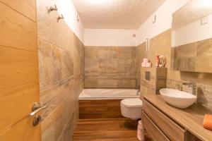 a bathroom with a sink and a toilet and a tub at Villa Solsticia in Albitreccia
