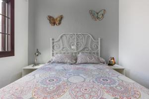 a bedroom with a bed with butterflies on the wall at Casa Mariposa in Caleta De Fuste +13 photos