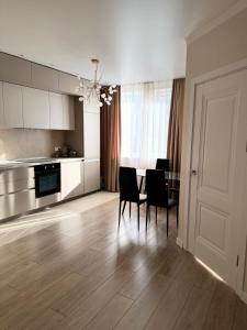 a kitchen and dining room with a table and chairs at VIP Apartments 57 in Odesa +22 photos