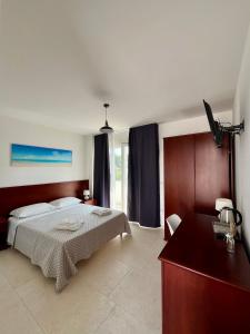 una camera con un letto e un comò di Rooms del Moro a Patù