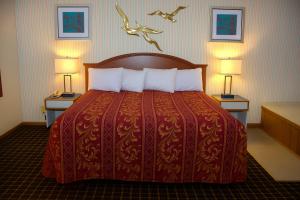 a hotel room with a bed with two tables and two lamps at Ventura Motel in Ludington