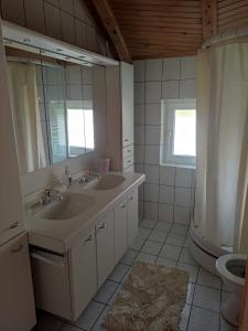 une salle de bain avec deux lavabos et un miroir dans l'établissement Guesthouse Nestoria Living, à Banja Luka