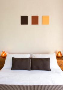 a bedroom with a white bed with two paintings on the wall at Auberge de la Croix Blanche in Villarepos +11 photos