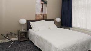 a bedroom with a white bed and two lamps at B&B House No 7 in Amsterdam