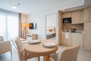 a dining room and kitchen with a table and chairs at Zenitude Hôtel Résidences Nice in Nice