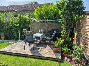 a garden with a table and chairs on a wooden deck at Ferienwohnung Gisela in Kolbermoor