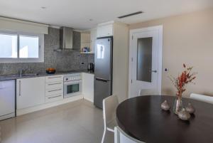 a kitchen with a table and a kitchen with a refrigerator at Altea Beach Villas in Altea