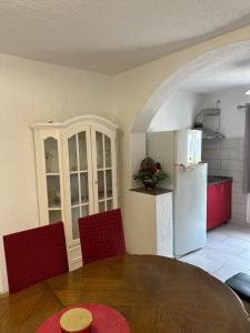 a kitchen with a table and red chairs and a refrigerator at Apartment King in Senj