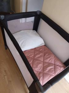 a small bed with a black frame and a white pillow at Dairy Cottage Courtyard accommodation in Bunmahon