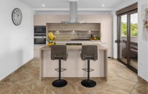 a kitchen with a counter and two stools in it at 4 Bedroom Gorgeous Home In Nova Vas in Nova Vas