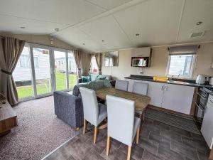 een caravankeuken en eetkamer met een tafel en stoelen bij Caravan In Scratby, Norfolk Ref 50071D in Great Yarmouth