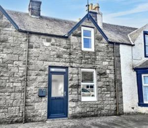 an old stone house with a blue door at Granite House in Carsphairn