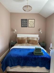 a bedroom with a bed with a blue blanket at Granite House in Carsphairn
