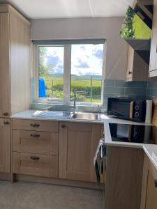 a kitchen with a sink and a window at Granite House in Carsphairn