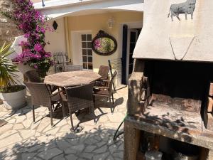 an outdoor patio with a table and chairs and a fireplace at La fleur d'oranger in Aigues-Mortes