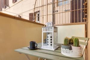 un tavolo con una tazza da caffè e un cactus su un balcone di Aurora Vatican House a Roma