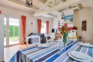 a dining room with a table with a blue and white table cloth at Jardin - Centre Noirmoutier - Maison pour 4 in Noirmoutier-en-l'lle