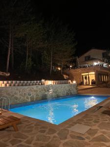 a swimming pool at night with a waterfall at Niceland İznik in Çamoluk