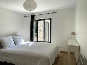 a bedroom with a white bed and a window at Maison de charme avec piscine, escapade, détente in La Rochelle +46 photos