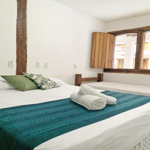 two beds with towels on them in a bedroom at Pousada Luz do Sol in Porto Seguro