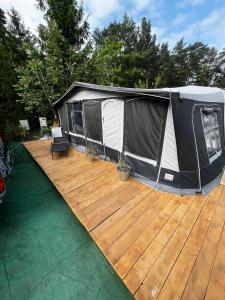 a black and white tent on a wooden deck at Kergulena in Hel