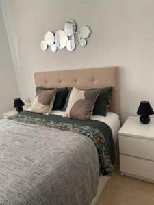 1 dormitorio con 1 cama con 3 luces en la pared en Villamar Cala, en Villajoyosa