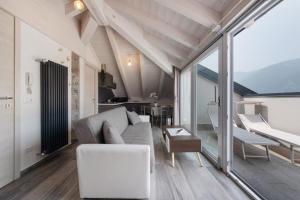 una sala de estar con un sofá y una mesa en White Suite - Jacuzzi, en Lezzeno