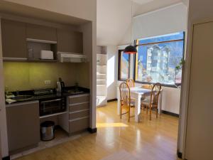 a kitchen and dining room with a table and chairs at Departamentos - Belgrano 810 in San Martín de los Andes
