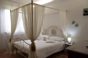 マルタにあるAgriturismo La Vita è Bellaのベッドルーム(白い天蓋付きベッド、白いカーテン付)