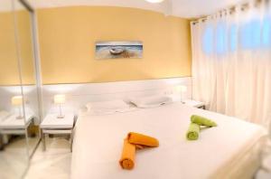 a bedroom with a white bed with towels on it at Malibu Beach Deluxe Wohnung Strandlage in Benalmádena