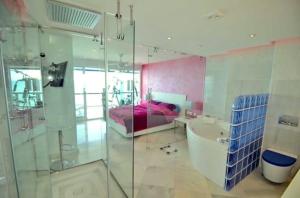 a bathroom with a shower and a tub and a bed at Malibu Beach Deluxe Wohnung Strandlage in Benalmádena +35 photos