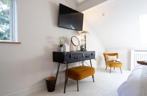 a bedroom with a dresser and a tv on a wall at Curlew Loft in Lancaster