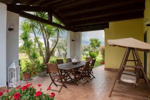 マルタにあるAgriturismo La Vita è Bellaの木製のテーブルと椅子、花が咲くパティオ