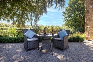 a table and two chairs with blue pillows on a patio at Curlew Loft in Lancaster
