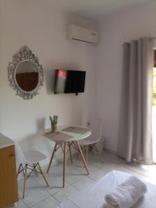 a living room with a table and a mirror at Baci Apartments in Ksamil