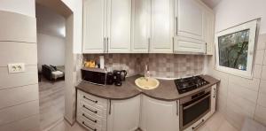 アラドにあるAda's cute apartmentのキッチン(白いキャビネット、シンク付きカウンター付) +6枚の写真