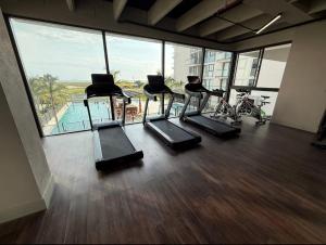 a gym with a row of treadmills in a building at Comfortable apartment near the beach in Playa Bello Horizonte