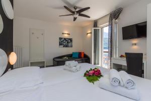 una camera da letto con un letto bianco con asciugamani e una scrivania di Hotel Riviera a Melide